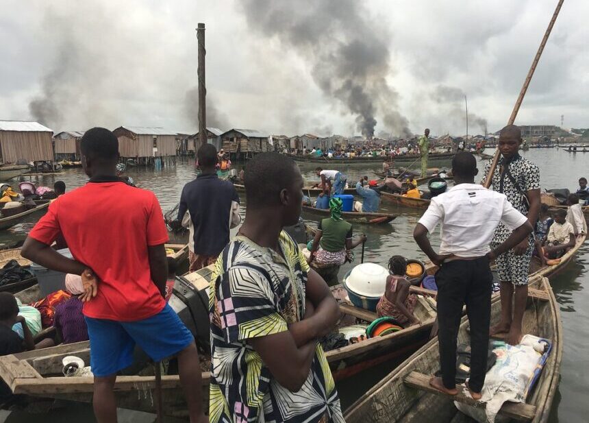 People in boats on the waterfront of Lagos look at their homes after being evicted in 2017