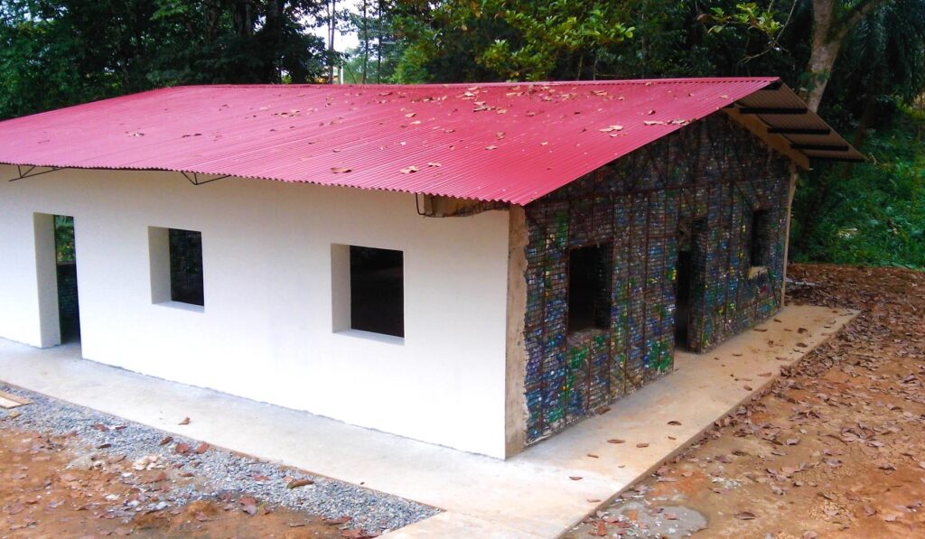 A partially built house with a red roof exposes one side built with plastic bricks.