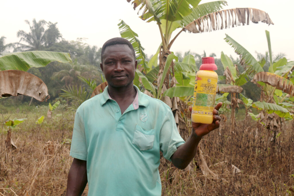 Aboabo villager poses with a pesticide bottle found near the GOPDC plantation.