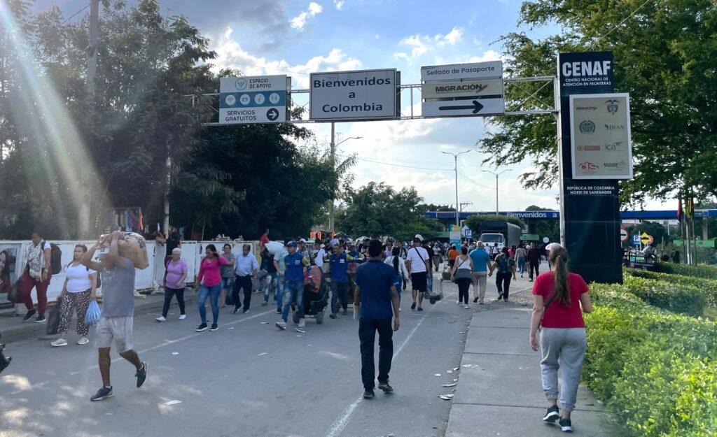 People walking over the border from Venezeula to Colombia on a sunny day.