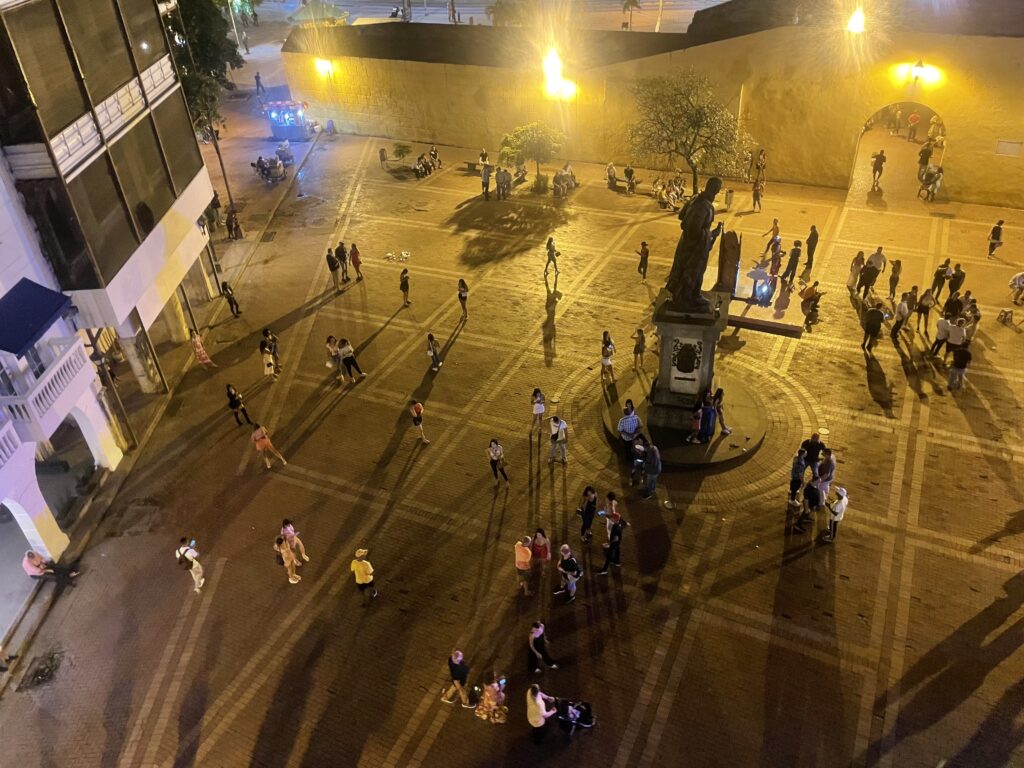 A busy square is seen from above in the twilight