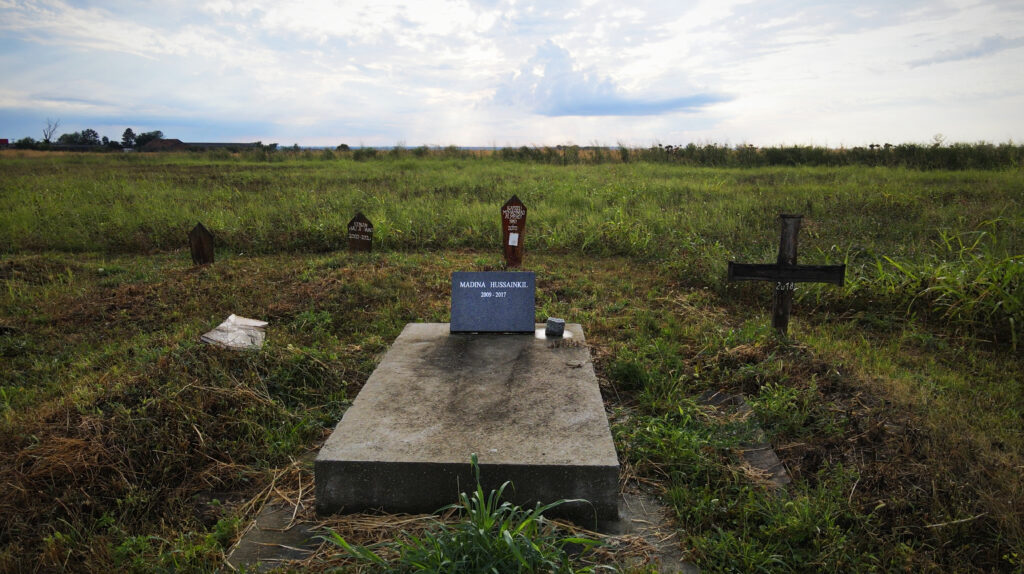A grave stands along several other markings in a field