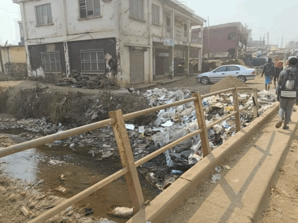 Garbage thrown into a bridge, near a building affected by flood (Mboh Promise)