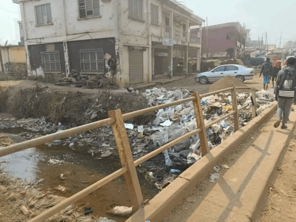 Garbage thrown into a bridge, near a building affected by flood (Mboh Promise)
