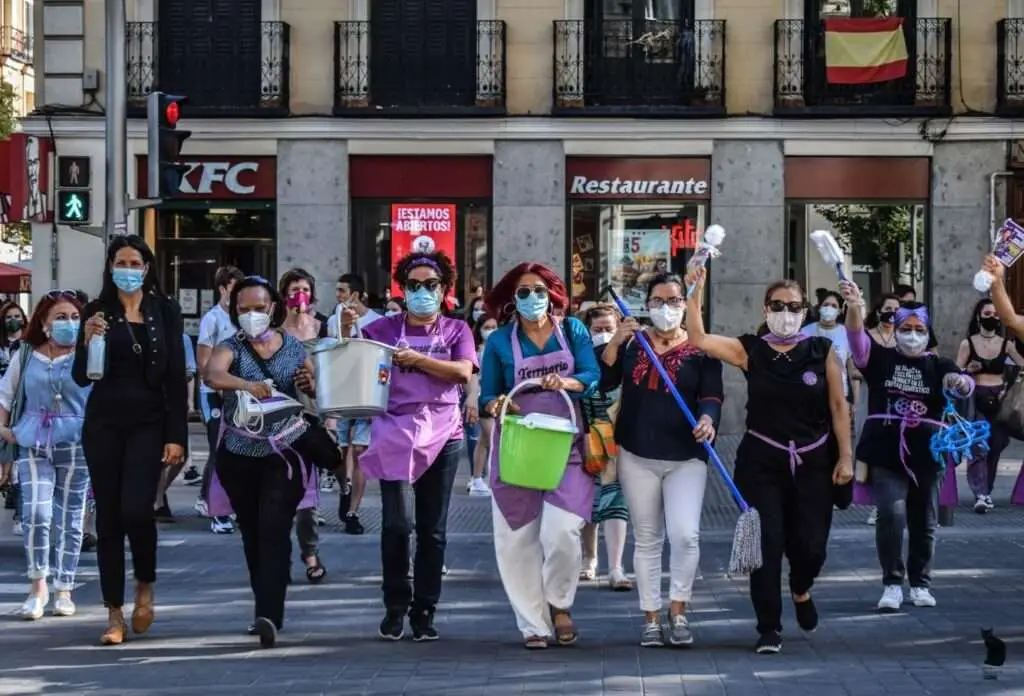 Rafaela Pimentel (center), alongside her compañeras from Territorio Doméstico, performs a catwalk during a demonstration in Madrid on 21 June 2020, calling for the ratification of Convention 189 (C189) and the regularization of migrants with irregular administrative status. Embracing their festive and joyful spirit, they bring music, flash mobs, and costumes to every protest.