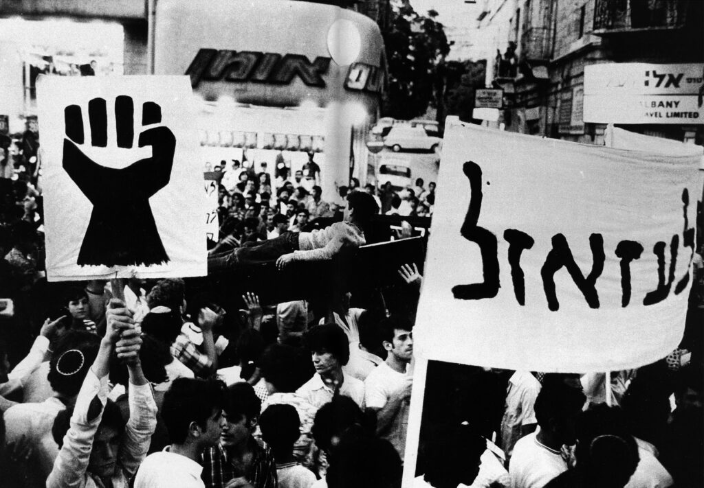 A banner at a Panther demo reads ‘To hell with it’, from The Black Panthers, published by Musrara School of Photography, 1999
